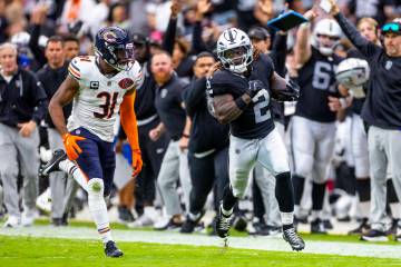 Raiders running back Ashton Jeanty (2) sprints down the sidelines pursued by Chicago Bears free ...