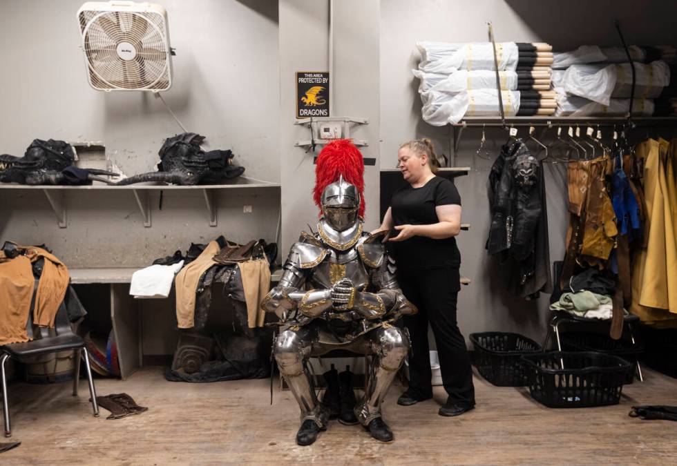 Shannon Lusk tends to a well-armored knight before a performance at the Tournament of Kings at ...