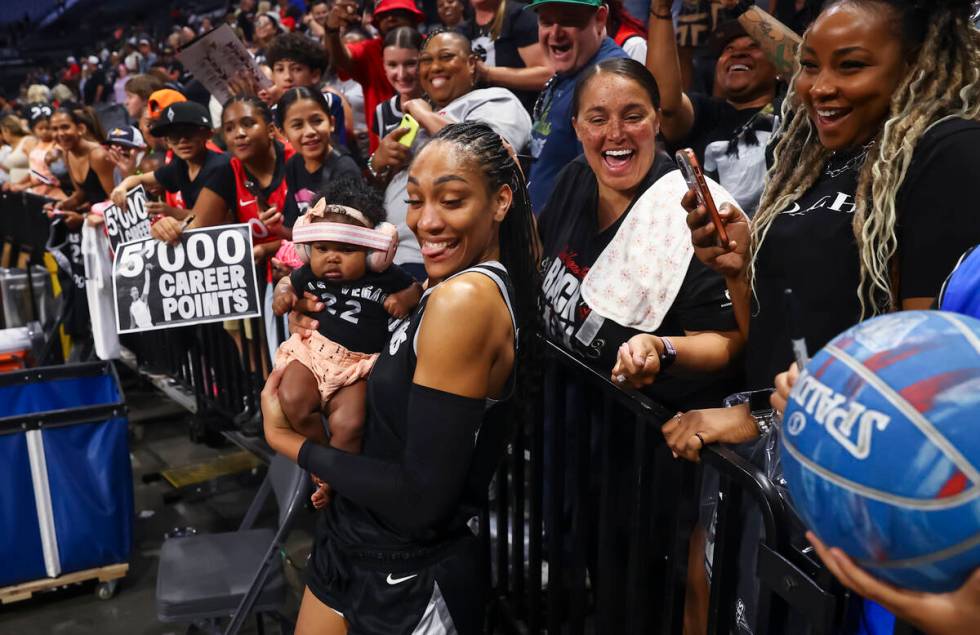 Aces center A'ja Wilson (22) holds a baby from the crowd after defeating the Connecticut S ...