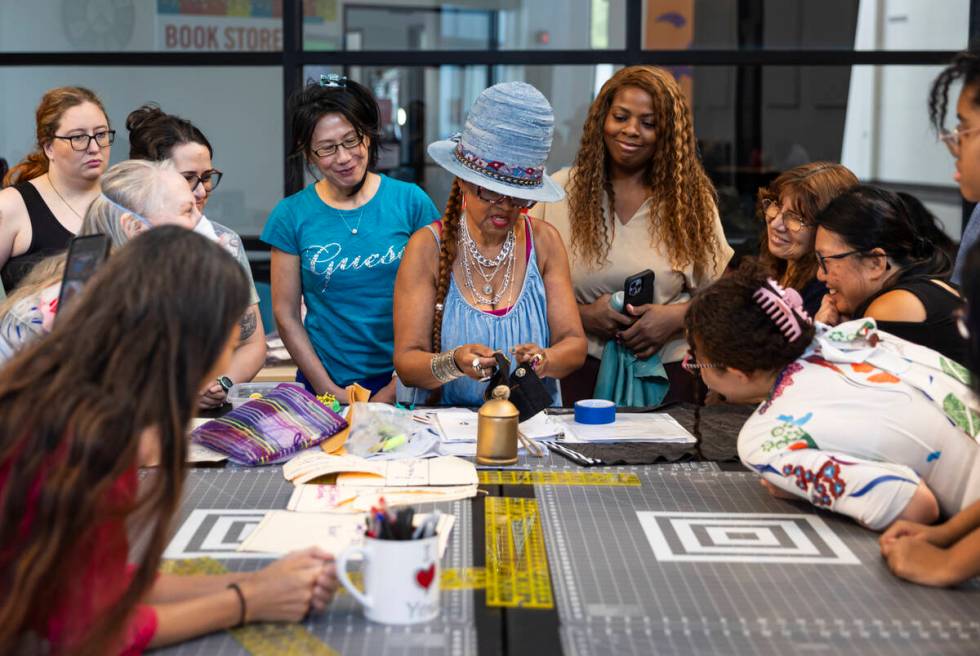 Course instructor Victoria Shaffer, center, demonstrates how to sew on snaps during a sewing co ...