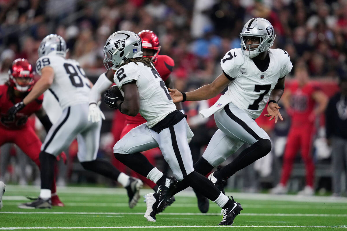 Las Vegas Raiders quarterback Geno Smith (7) hands off to running back Ashton Jeanty (2) during ...