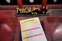 A Powerball play slip sits on the lottery ticket counter at a gas station, Friday, Aug. 29, 202 ...