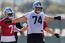 Raiders offensive tackle Kolton Miller (74) warms up in front of quarterback Geno Smith (7) dur ...