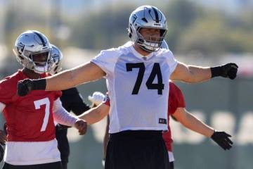 Raiders offensive tackle Kolton Miller (74) warms up in front of quarterback Geno Smith (7) dur ...