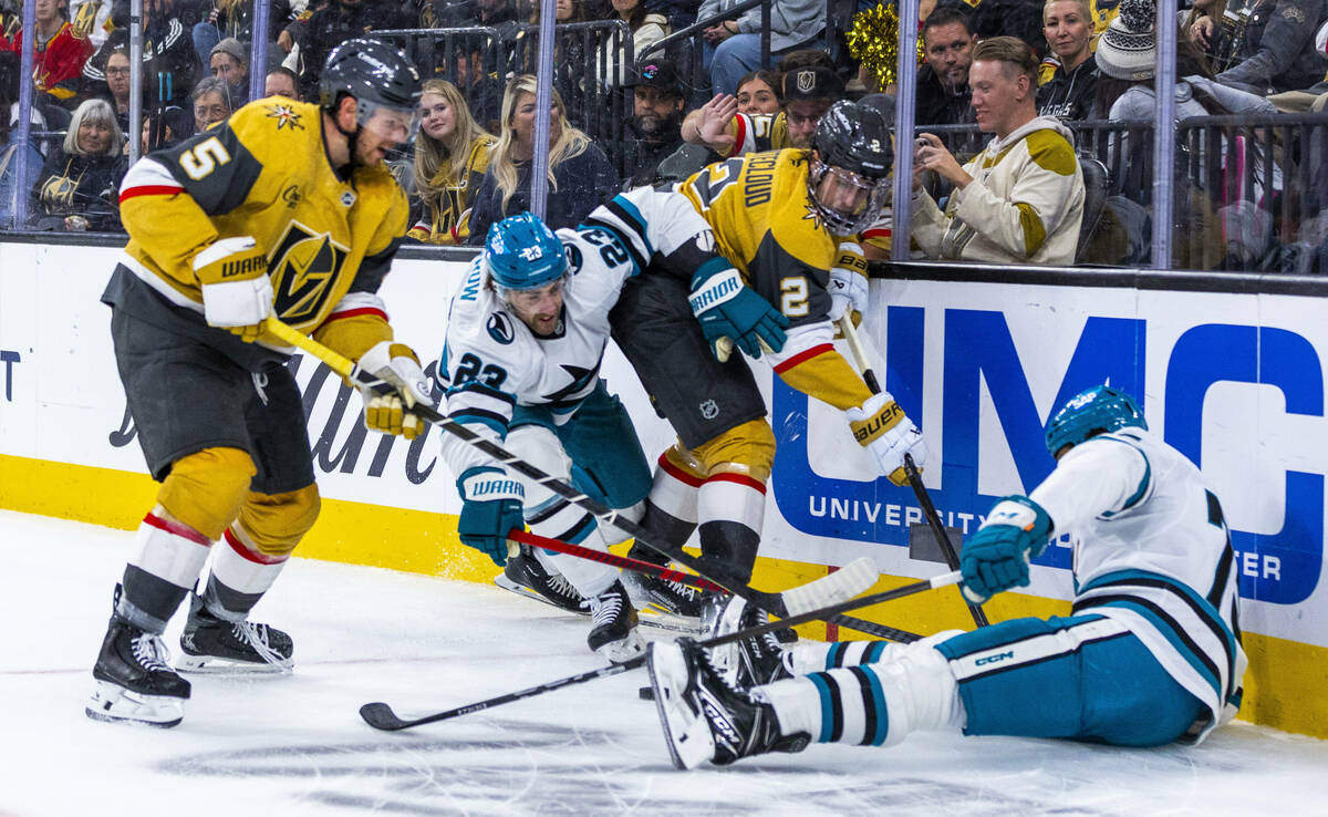 Golden Knights defenseman Zach Whitecloud (2) and defenseman Jeremy Lauzon (5) battle with San ...
