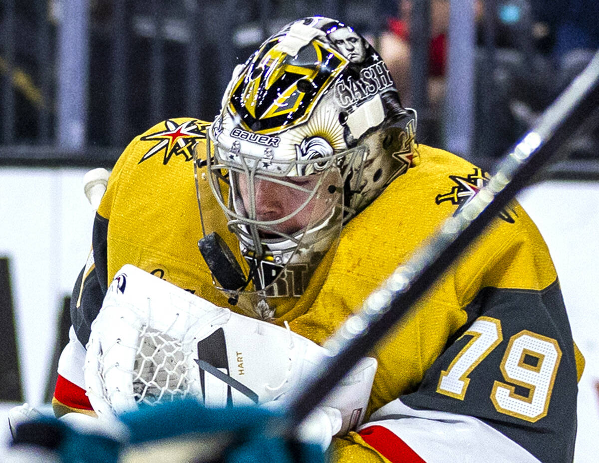 Golden Knights goaltender Carter Hart (79) stops the puck which gets caught in his mask against ...