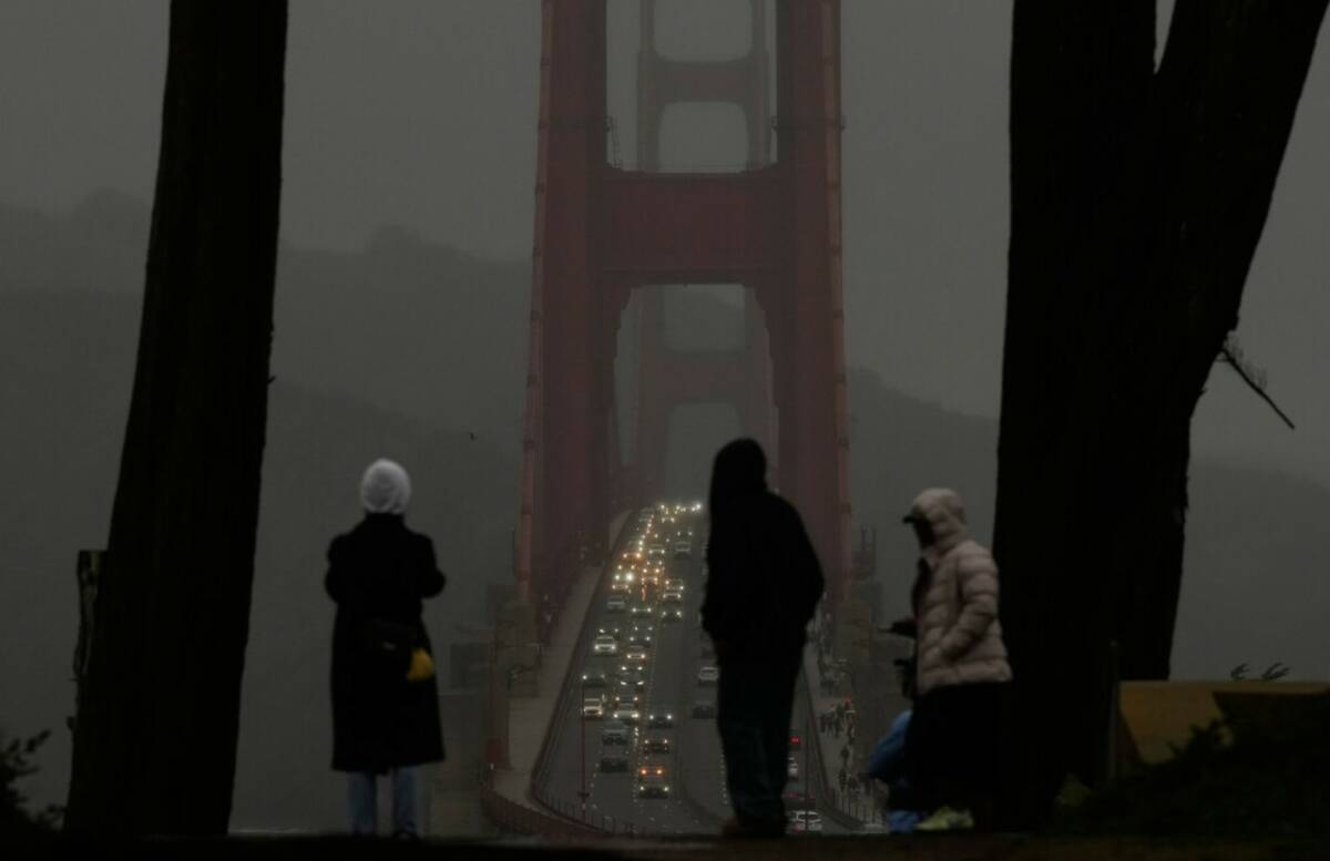People look toward traffic on the Golden Gate Bridge from the Golden Gate Overlook in San Franc ...