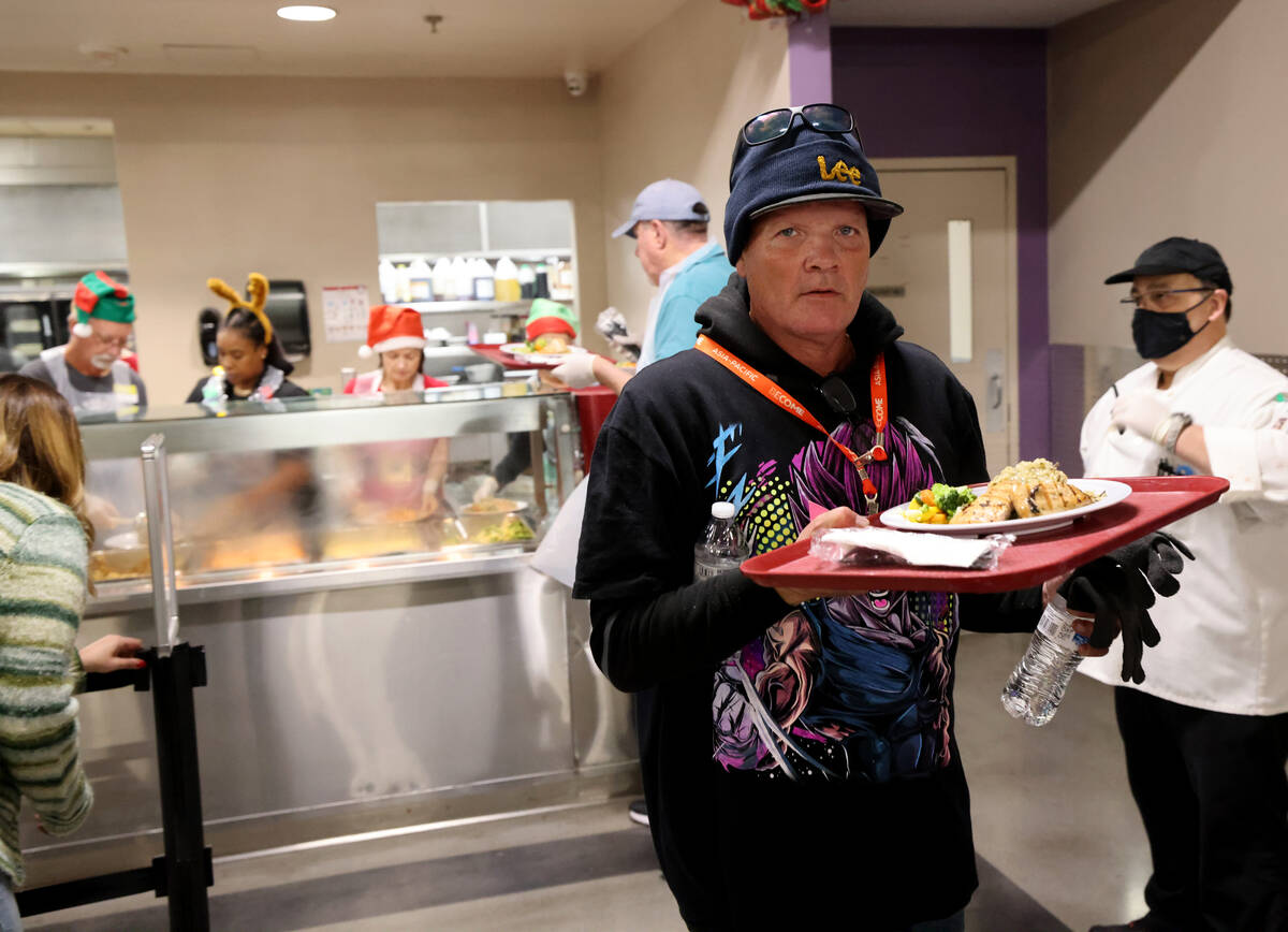 A guest grabs a Christmas meal at Catholic Charities of Southern Nevada in Las Vegas Thursday, ...