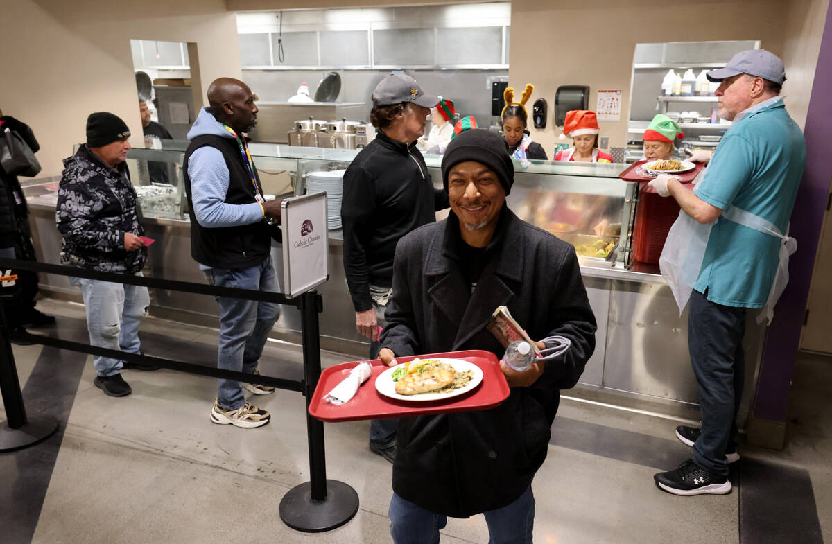 A guest grabs a Christmas meal at Catholic Charities of Southern Nevada in Las Vegas Thursday, ...