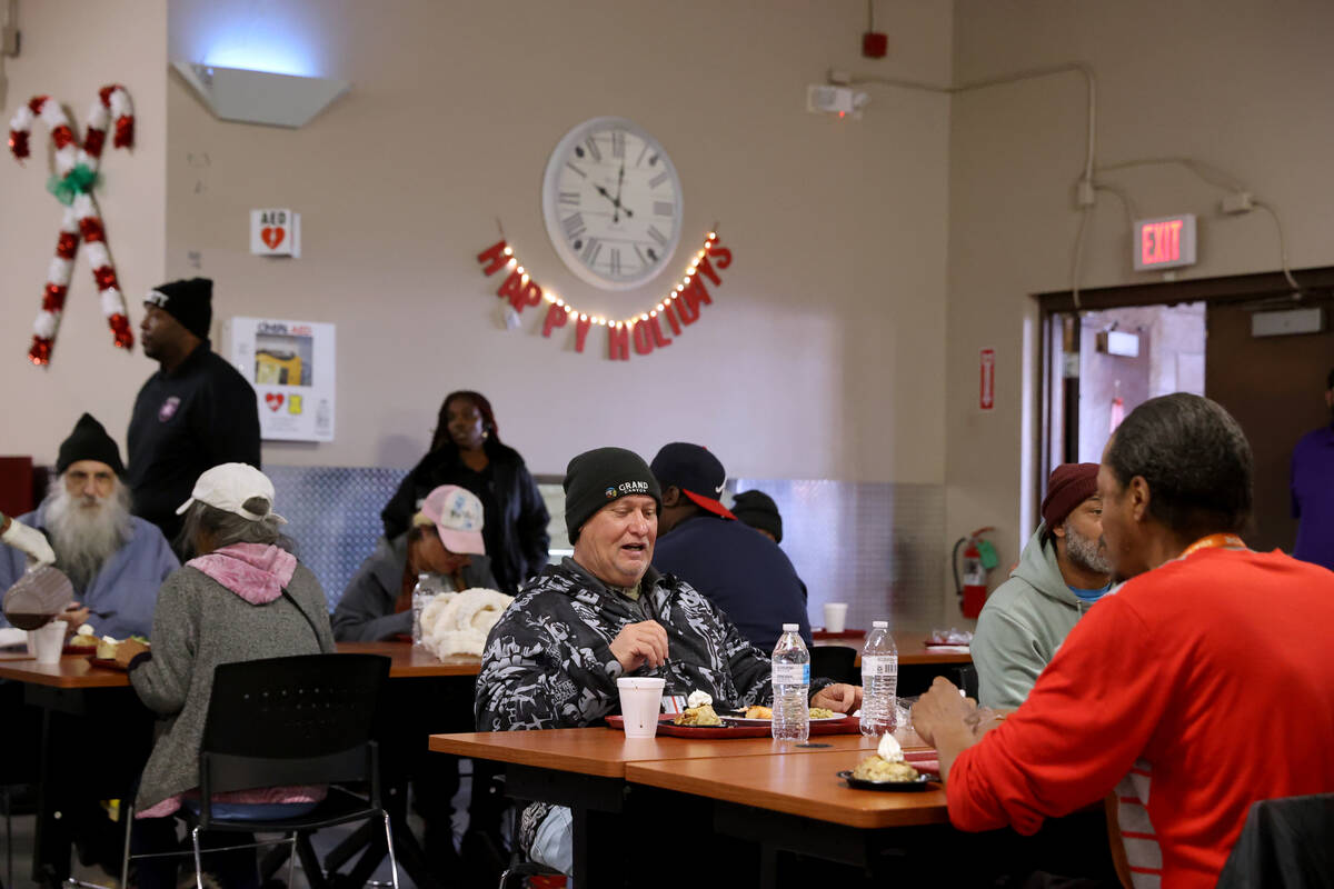 Guests, including Patrick Connelly, 60, center, eat Christmas meals at Catholic Charities of So ...