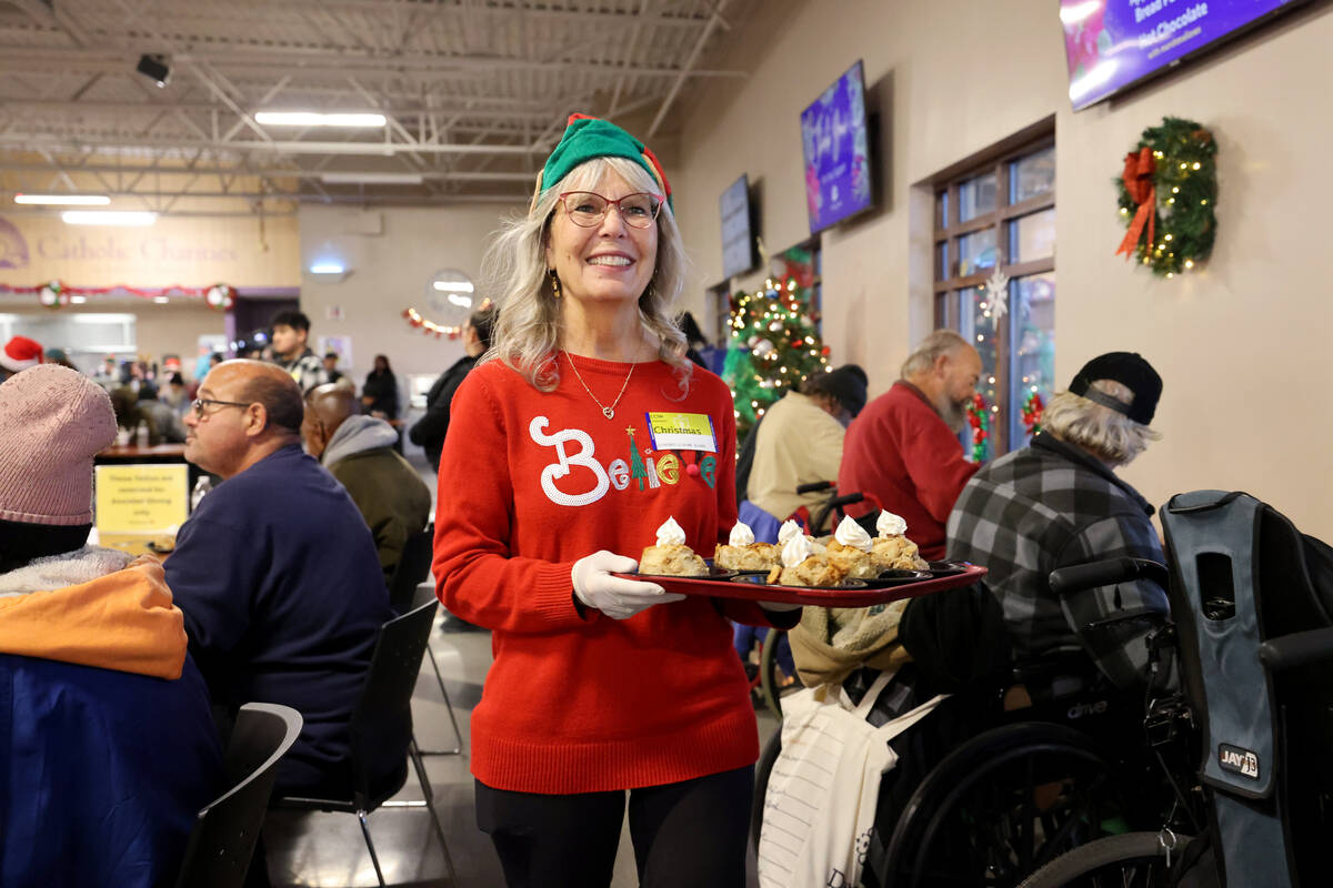 Volunteer Roxanne Ropella serves dessert during a Christmas meal at Catholic Charities of South ...