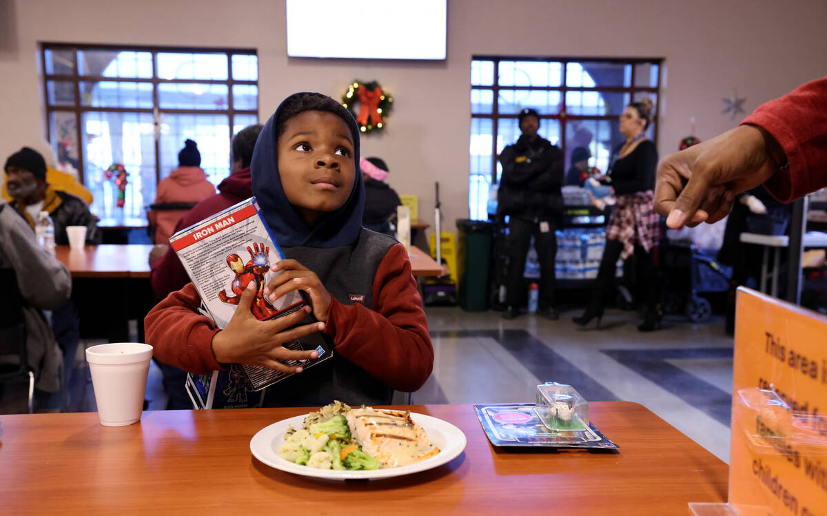 Manny Baker, 6, receives toys during a Christmas meal at Catholic Charities of Southern Nevada ...