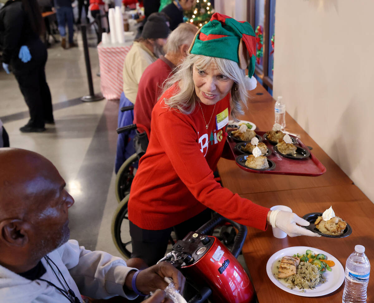 Volunteer Roxanne Ropella serves dessert during a Christmas meal at Catholic Charities of South ...