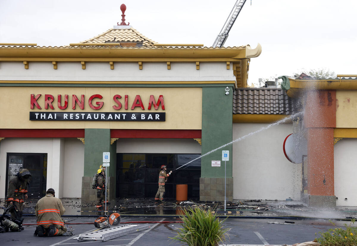 People watch as Clark County and North Las Vegas firefighters are battling a fire that erupted ...