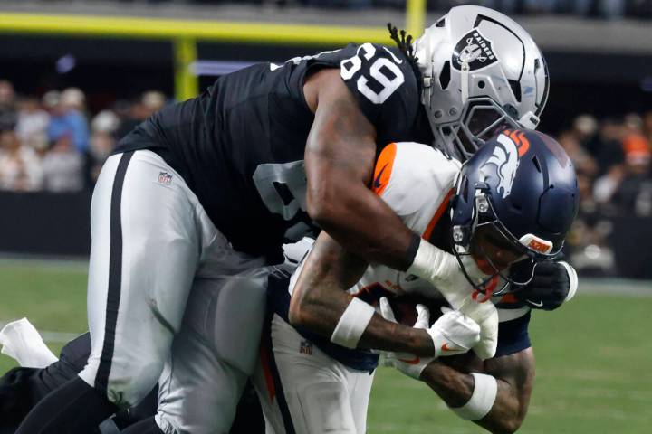 Denver Broncos wide receiver Troy Franklin (11) is taken down by Raiders defensive tackle Adam ...