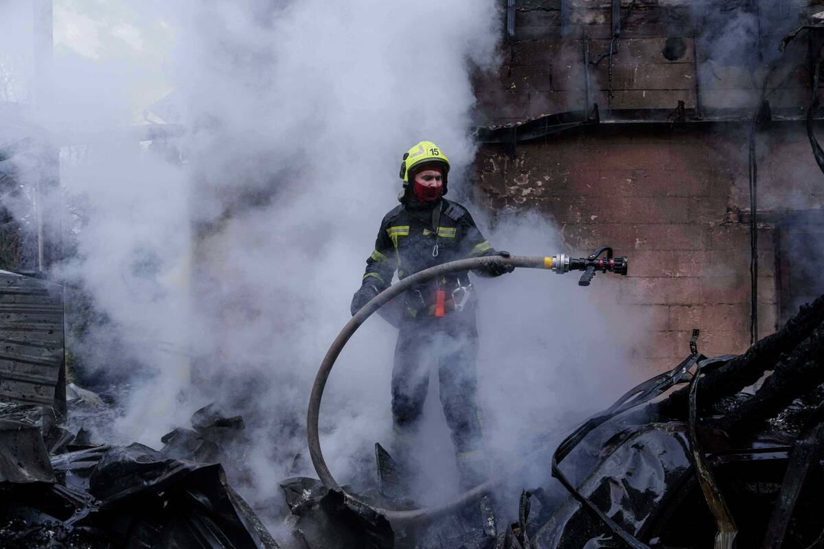 A rescue worker puts out a fire of a house destroyed after a Russian strike on Kyiv, Ukraine, o ...