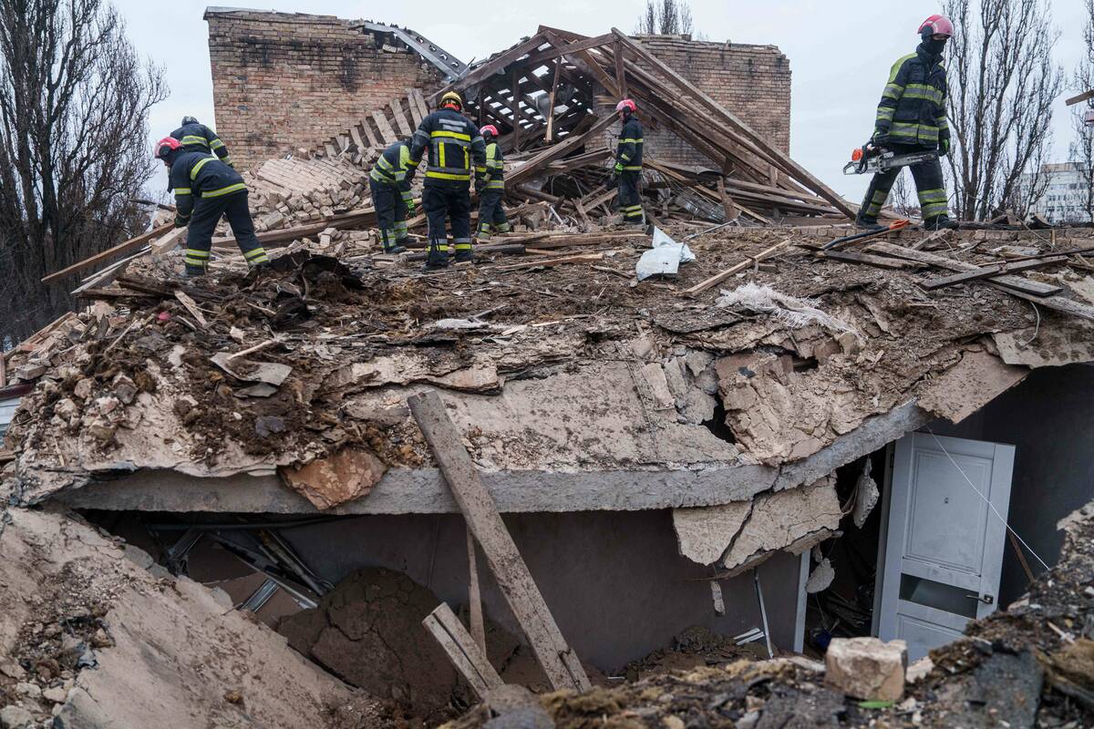Rescue workers clear the rubble at the roof of apartment building damaged after a Russian strik ...