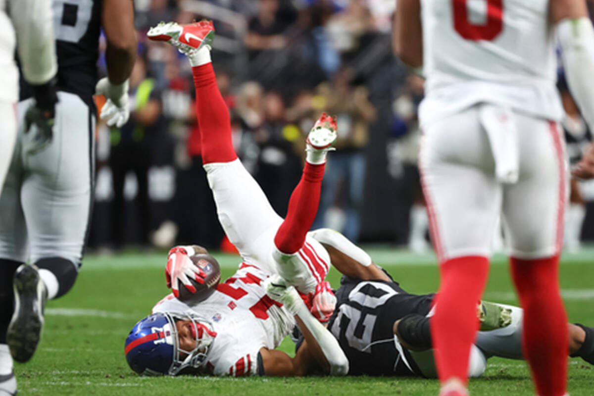 New York Giants wide receiver Wan'Dale Robinson (17) gets tackled by Raiders safety Isaiah Pola ...