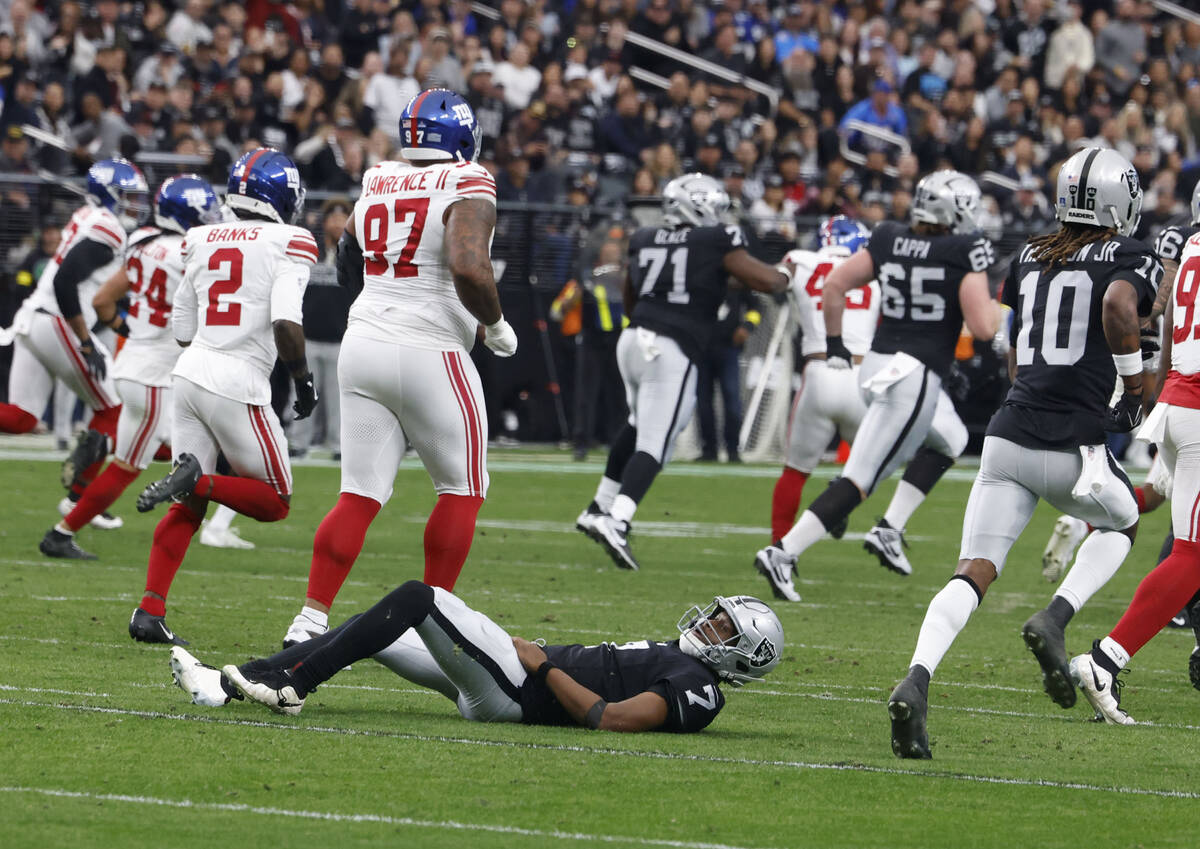 Raiders quarterback Geno Smith (7) lays on the ground after his pass was intercepted by Giants ...