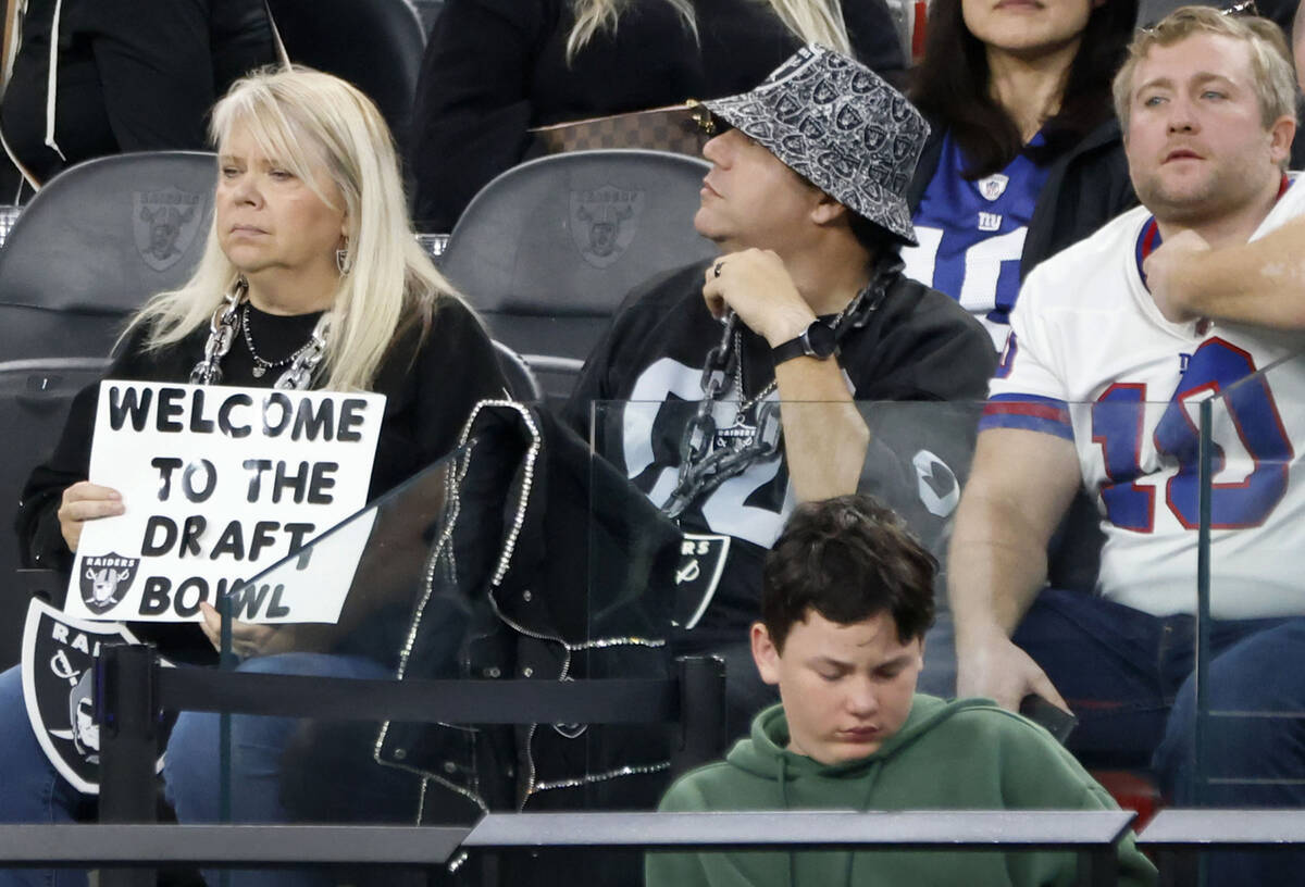 A Raiders fan hold a sign as she watches the gmae against the New York Giants during the second ...