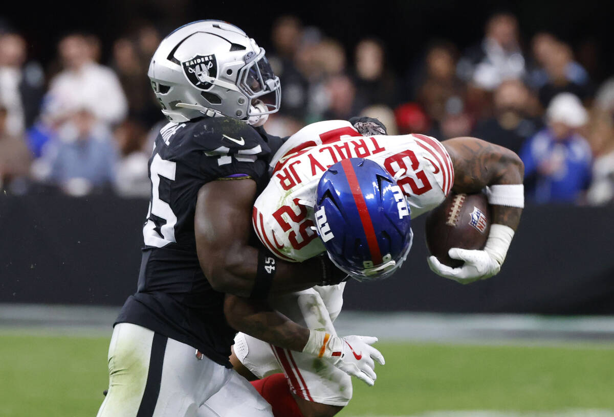 Giants safety Anthony Johnson Jr. (23) is taken down by Raiders linebacker Devin White (45) dur ...