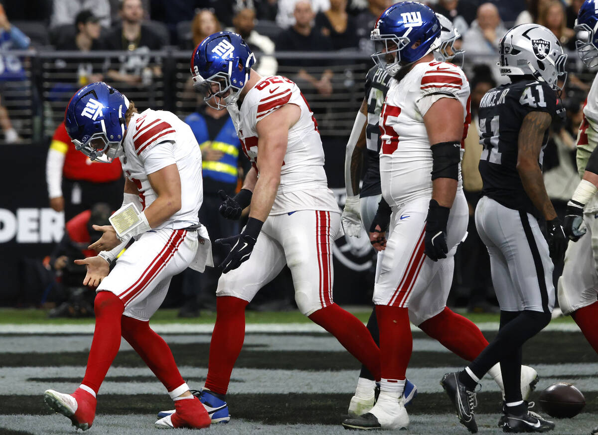 Giants quarterback Jaxson Dart, left, celebrates his touchdown during the first half of an NFL ...