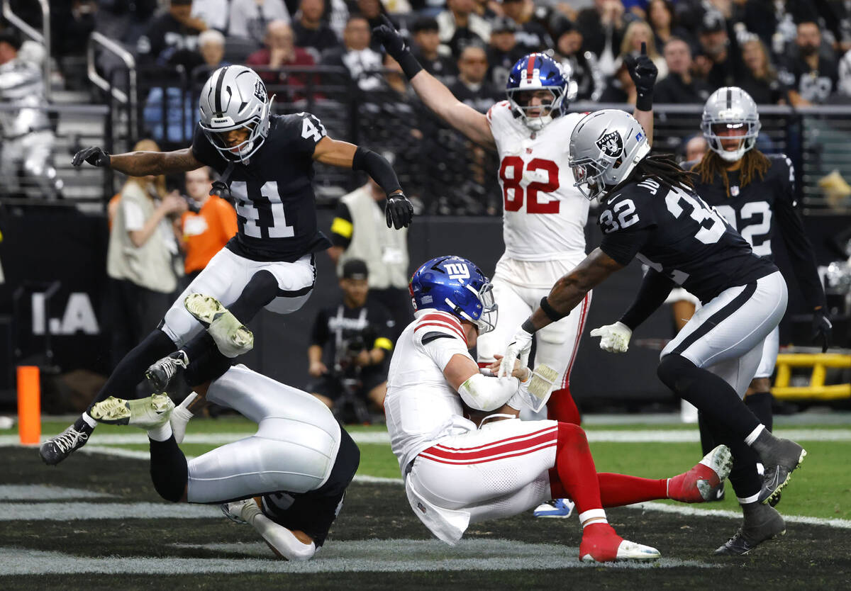 Giants quarterback Jaxson Dart, center, scores a touchdown during the first half of an NFL game ...