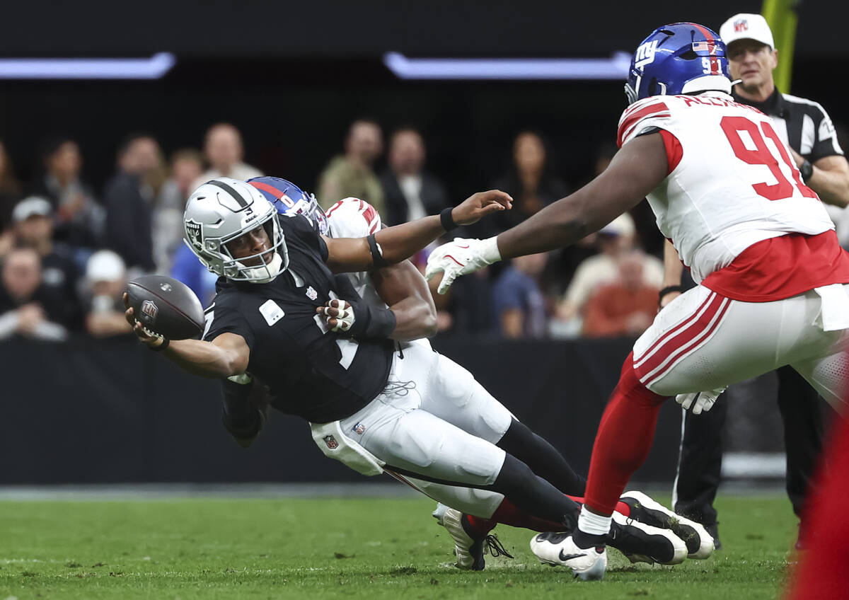 Raiders quarterback Geno Smith (7) gets sacked by New York Giants linebacker Brian Burns (0) du ...