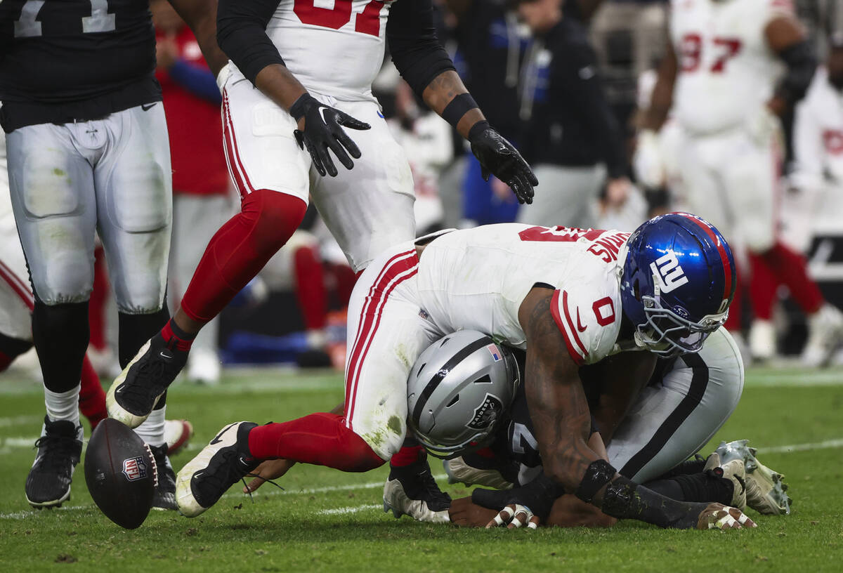 Raiders quarterback Geno Smith (7) gets sacked by New York Giants linebacker Brian Burns (0) du ...