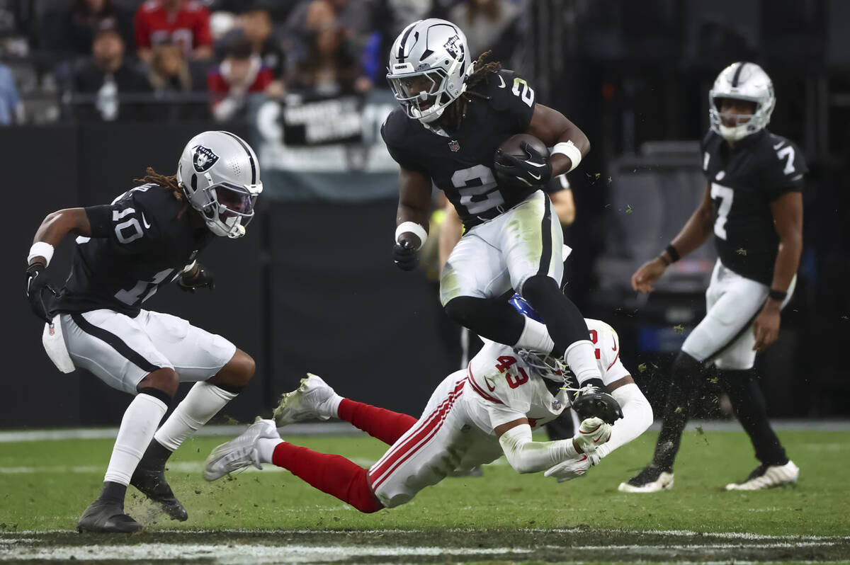 Raiders running back Ashton Jeanty (2) jumps past New York Giants safety Raheem Layne (43) duri ...