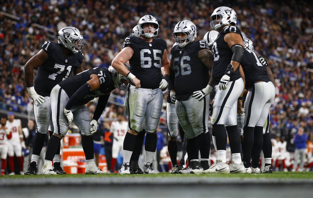 Members of the Raiders offensive line huddle during the second half of an NFL game against the ...