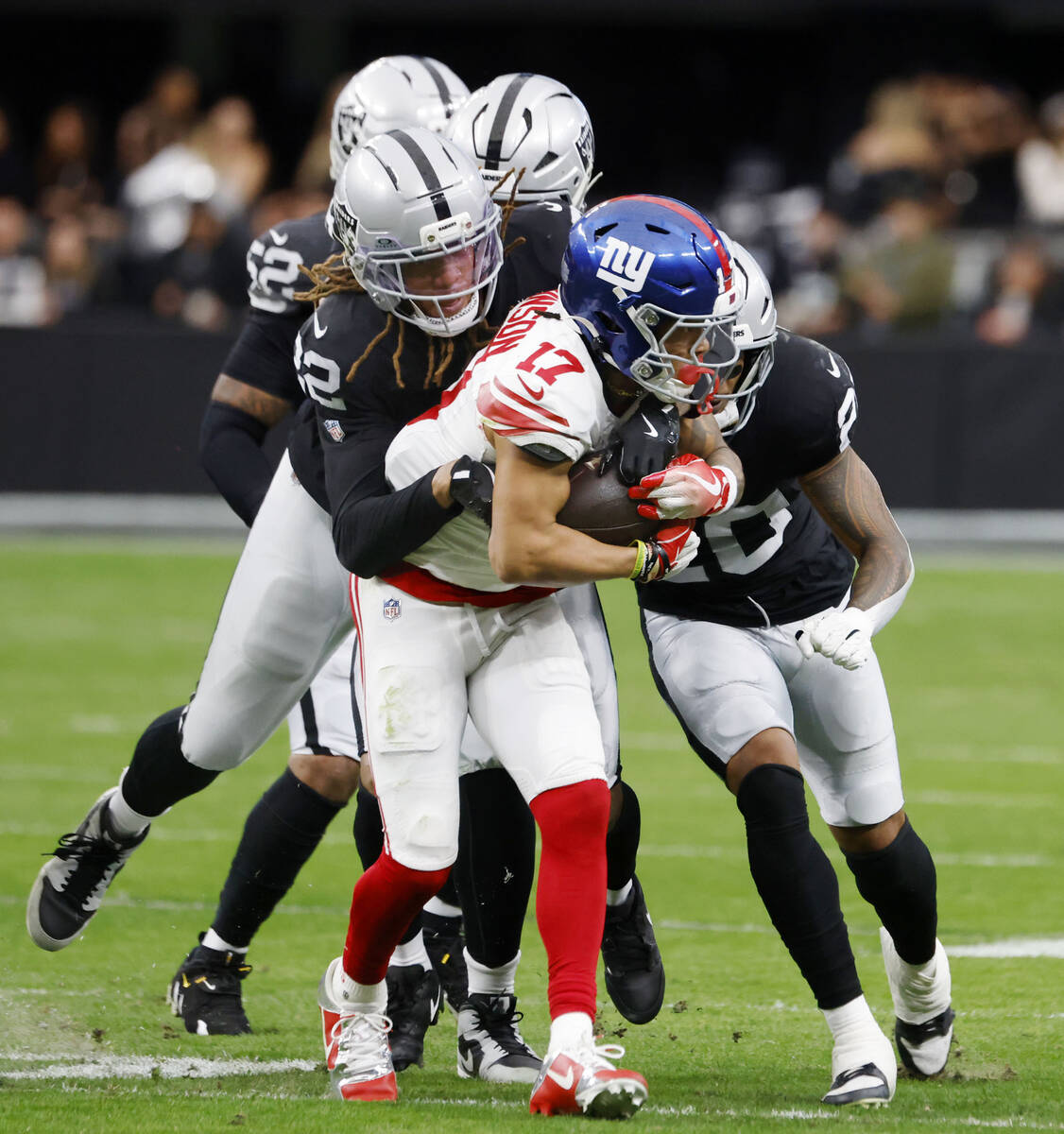 Giants wide receiver Wan'Dale Robinson (17) is taken down by Raiders defense during the fi ...