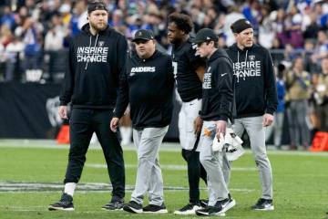 Raiders offensive tackle Kolton Miller, left, walks with training staff and Raiders quarterback ...