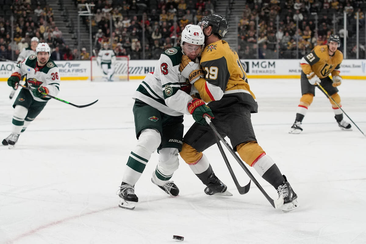 Vegas Golden Knights right wing Reilly Smith (19) checks Minnesota Wild defenseman Quinn Hughes ...