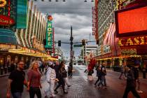 People cross Casino Center Boulevard along Fremont Street during a rainy afternoon on Wednesday ...