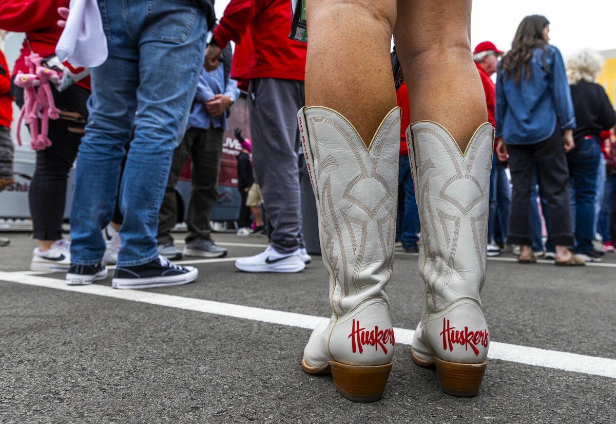 A Nebraska fan is covered down to her boots in team promotion in the pre-game fan fest before t ...