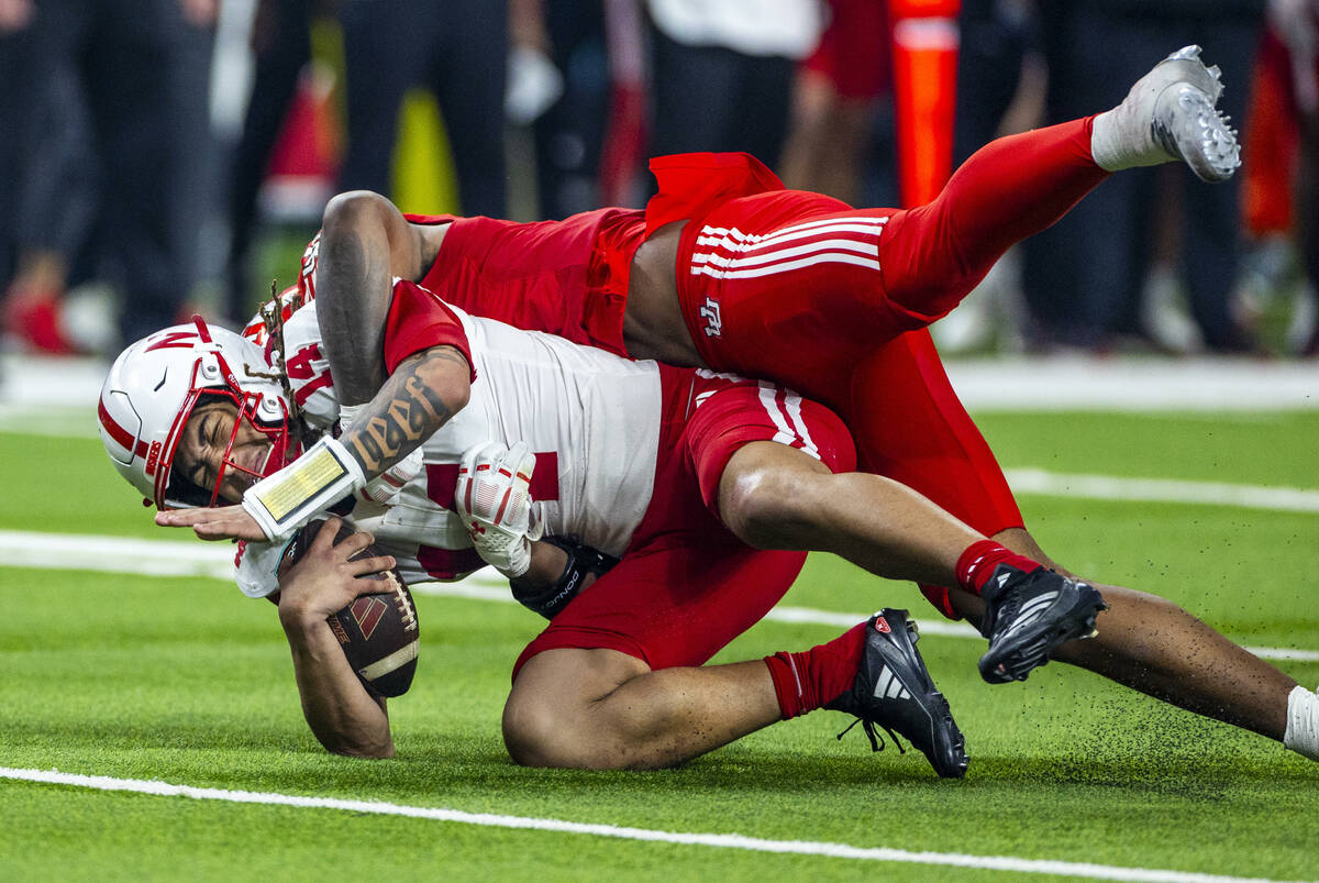 Nebraska Cornhuskers quarterback TJ Lateef (14) is sacked by Utah Utes defensive end Lance Holt ...