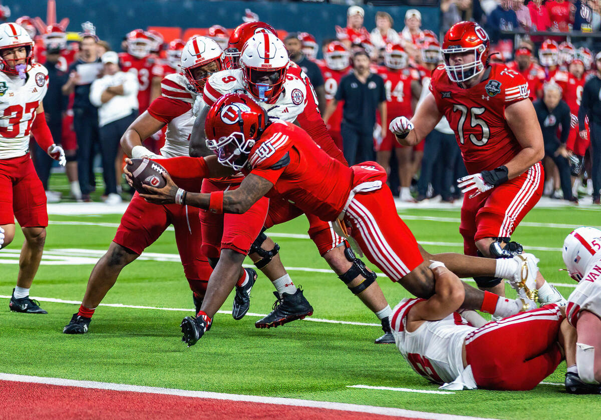 Utah Utes quarterback Devon Dampier (4) extends the ball over the goal line for a touchdown aga ...