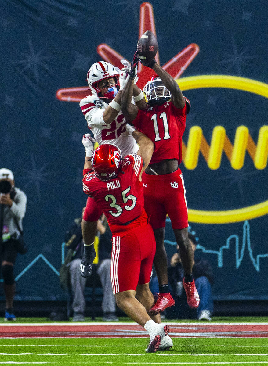 Utah Utes defensive back Rock Caldwell (11) battles for a long pass interception over Nebraska ...