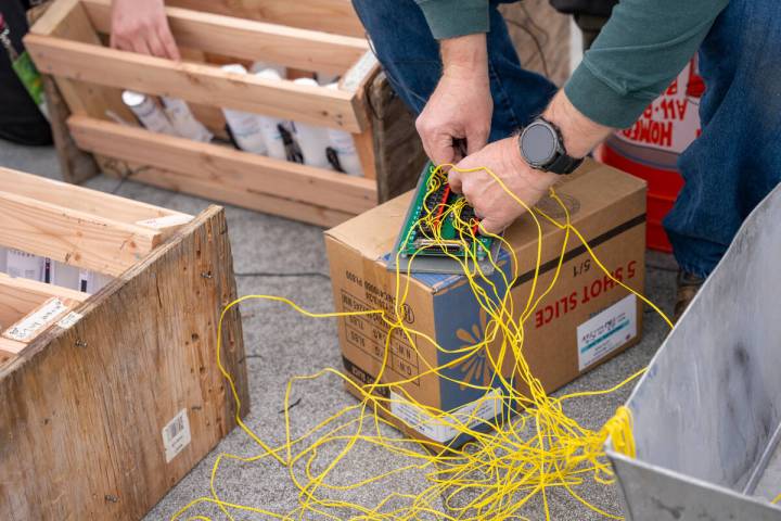 Pyrotechnic assistant Erik Peterson wires fireworks ahead of New Year’s Eve on the roof ...