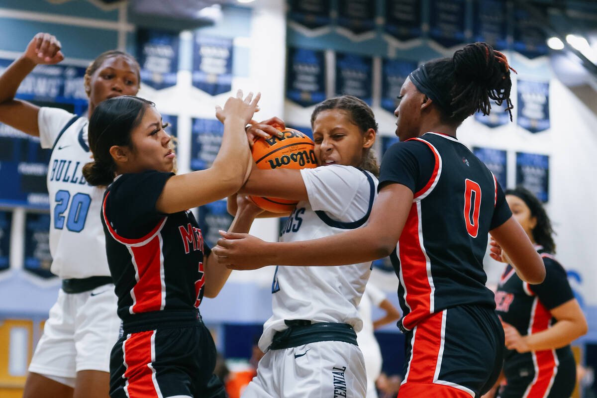 Mater Academy’s Karina Gallegos (2) and Amija Macon (0) try to wrestle there ball from C ...