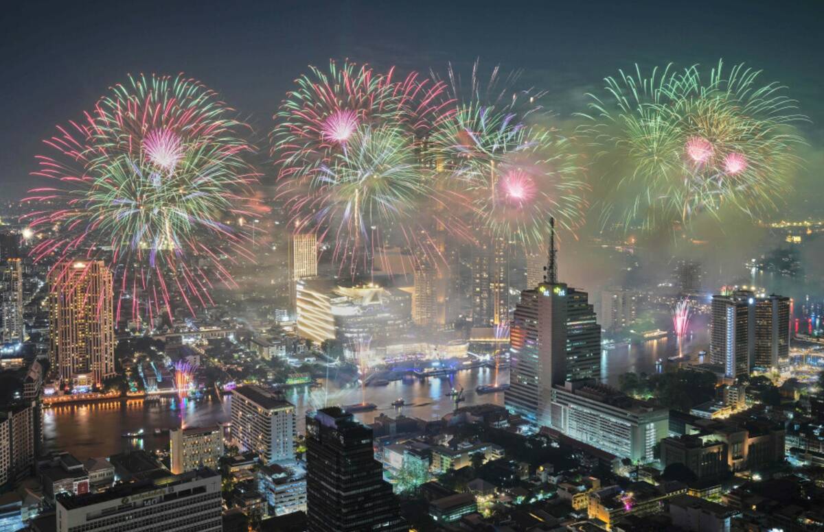 Fireworks explode over the Chao Phraya River during New Year celebrations in Bangkok, Thailand, ...