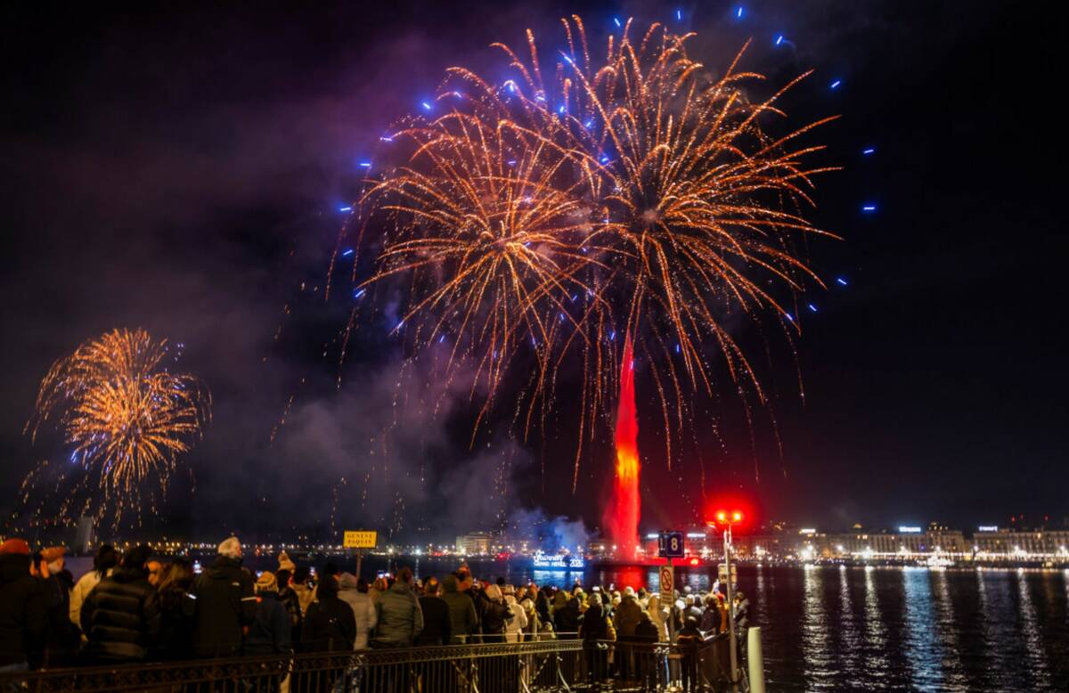 Fireworks illuminate the sky in bay of Geneva behind the famous water fountain "Le Jet d'Eau", ...