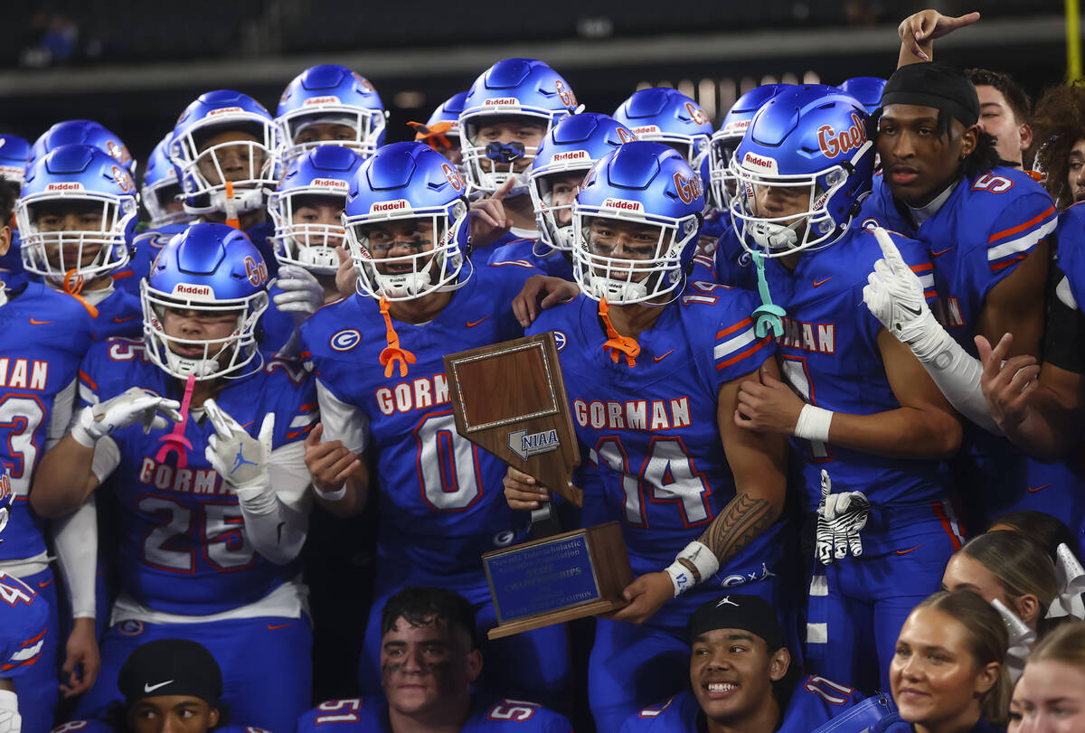 Bishop Gorman players pose for photos with the trophy after defeating Arbor View to win the Ope ...