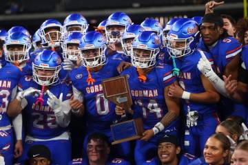 Bishop Gorman players pose for photos with the trophy after defeating Arbor View to win the Ope ...