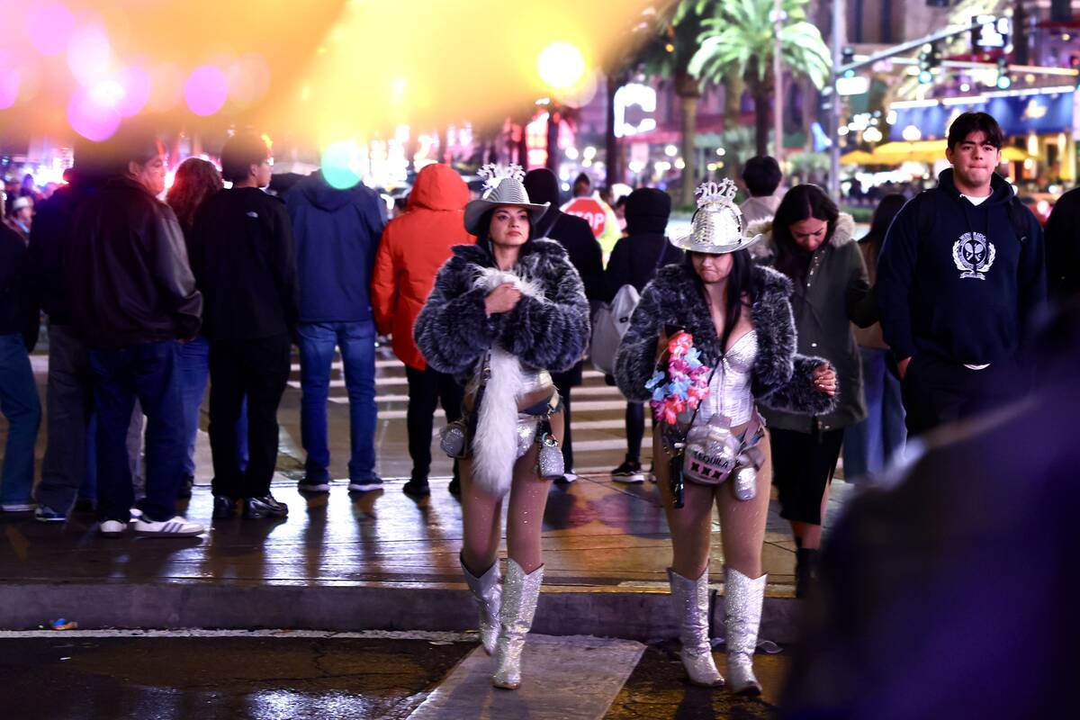 Revelers walk down the Las Vegas Strip on New Year's Eve, Dec. 31, 2025. (Liv Paggiarino/Las Ve ...