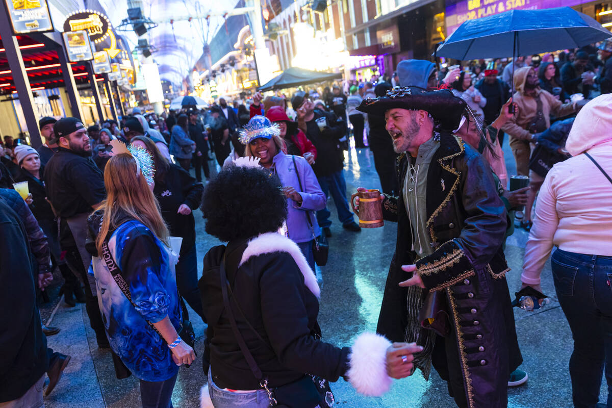 Mike Frank, of Seattle, right, mingles with other New Year's revelers at the Fremont Stree ...