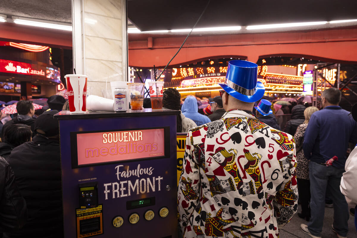 People try to stay out of the rain as New Year's revelers gather at the Fremont Street Exp ...