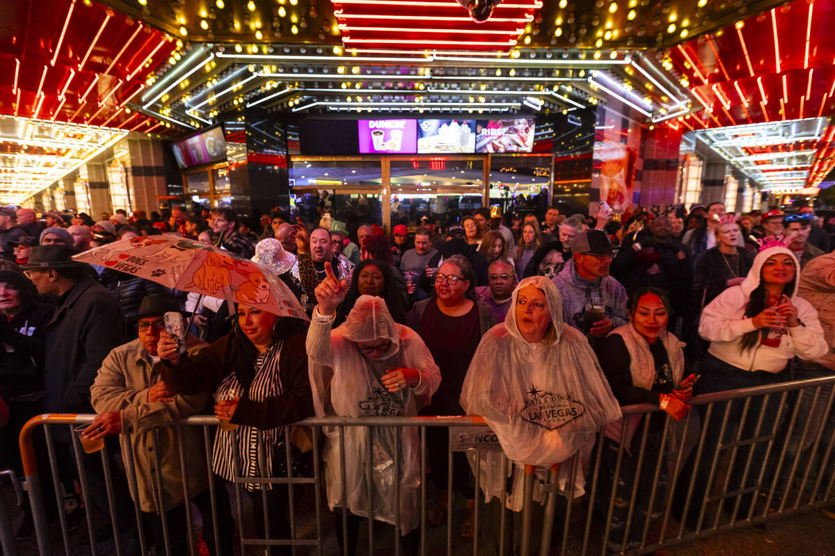People watch and sing along as Robin Thicke, not pictured, performs for New Year's reveler ...