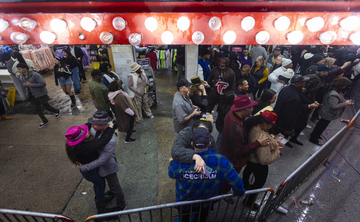 Couples kiss and embrace as revelers celebrate the new year at the Fremont Street Experience on ...